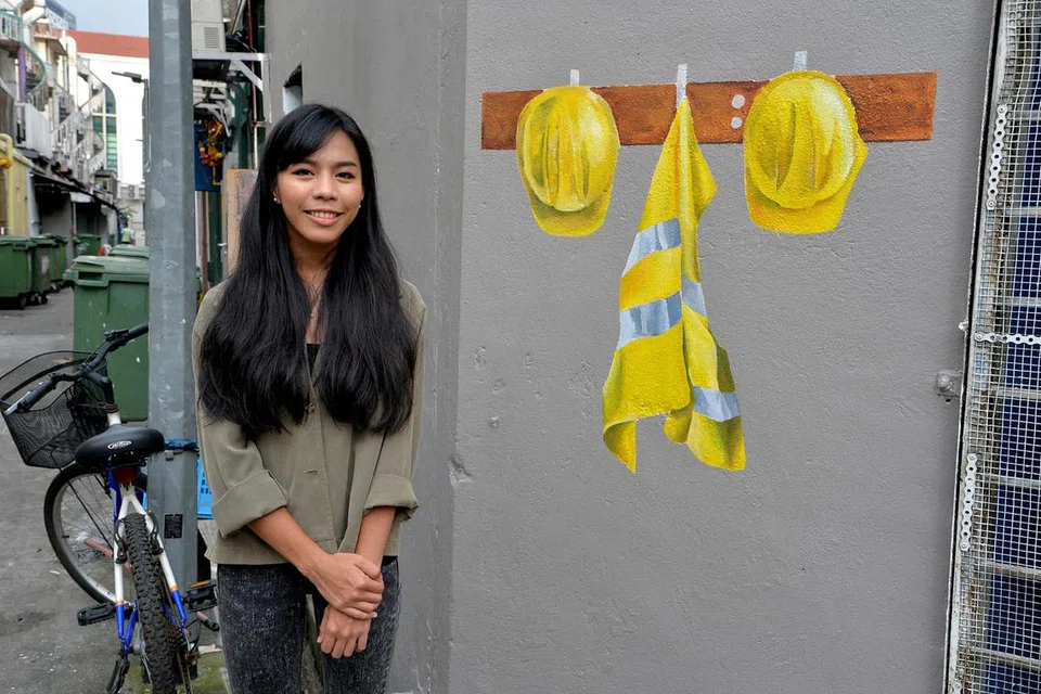  SANJUNG JERIH PAYAH PEKERJA ASING: Lukisan tembok yang tampak realistik dengan memaparkan topi keledar dan jaket keselamatan buruh asing ini dihasilkan oleh Cik Nadiah Alsagoff sebagai penghargaan terhadap pengorbanan mereka berjauhan daripada keluarga demi mencari rezeki. - Foto M.O. SALLEH