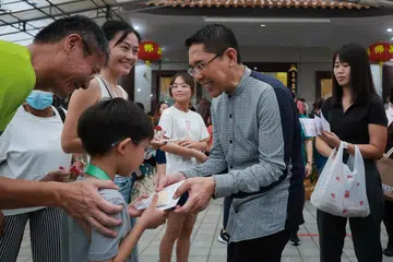 Menteri di Pejabat Perdana Menteri yang juga Anggota Parlimen bagi GRC East Coast, Dr Mohamad Maliki Osman, mengagihkan biskut suji berbentuk teratai di Kuil Man Fatt Lam di Bedok sempena Hari Vesak pada 22 Mei.