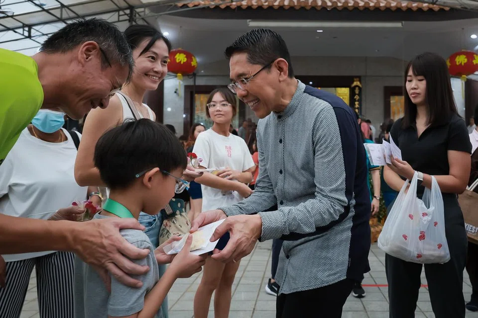 Menteri di Pejabat Perdana Menteri yang juga Anggota Parlimen bagi GRC East Coast, Dr Mohamad Maliki Osman, mengagihkan biskut suji berbentuk teratai di Kuil Man Fatt Lam di Bedok sempena Hari Vesak pada 22 Mei.