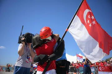 Atlet luncur lelayang Singapura, Maximilian Maeder, mendakap ibunya selepas perlumbaan peringkat akhir di Olimpik Paris di Marseille Marina pada 9 Ogos 2024.