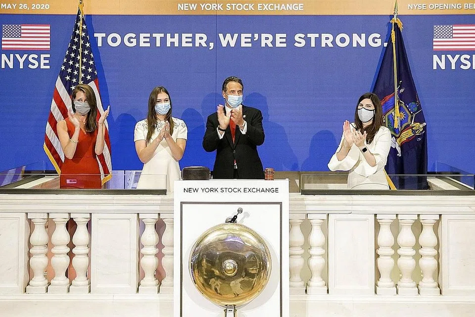 BUKA SEMULA BURSA SAHAM: Encik Andrew Cuomo sedang menepuk tangan selepas membunyikan loceng pembukaan di NYSE setelah ditutup selama tempoh dua bulan. - Foto EPA-EFE