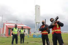 DEMONSTRASI TUGAS: Pegawai pasukan gangguan 'mobile' atau mudah alih (kanan) dan pegawai penguatkuasa lapangan bersama radar sistem pesawat yang tidak dikemudi manusia (tengah) di Lapangan Terbang Changi. - Foto BH oleh ONG WEE JIN 