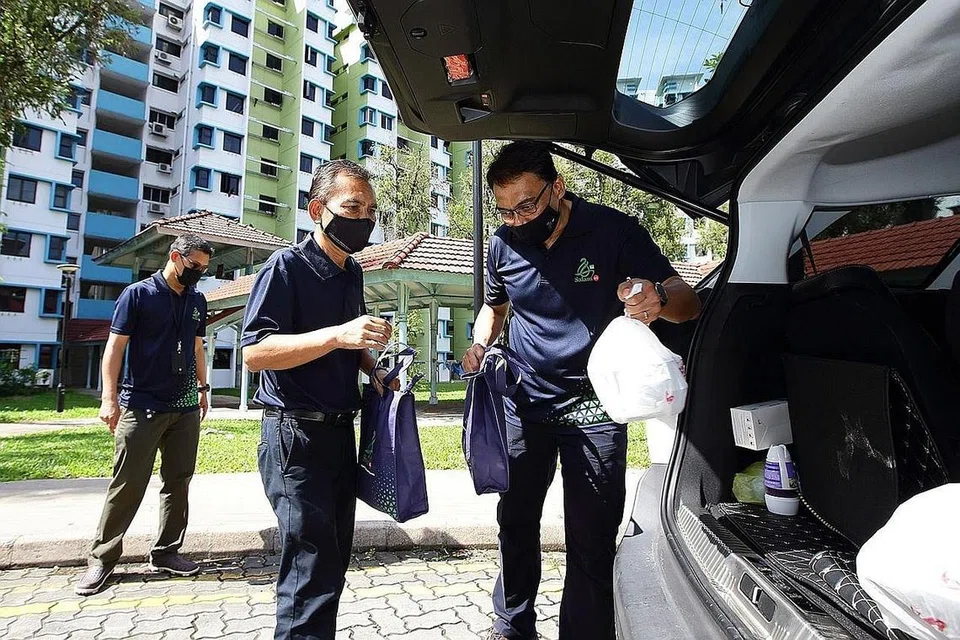 TURUN PADANG: Encik Kadir (kanan) dan Presiden Muis, Encik Saat Abdul Rahman (tengah) membantu memindahkan bungkusan daging korban dan paket beriani ke dalam kenderaan untuk diagihkan kepada penerima bantuan kebajikan Muis. - Foto MUIS