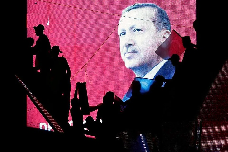 MAHU BERTINDAK TEGAS: Bayang-bayang penyokong Encik Recep Tayyip Erdogan terpapar pada skrin yang menunjukkan wajah Presiden Turkey itu semasa satu perhimpunan propemerintah di Ankara, Turkey, kelmarin. - Foto REUTERS