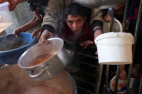 KEKURANGAN MAKANAN: Penduduk Gaza termasuk kanak-kanak terpaksa berebut-rebut untuk mendapatkan makanan yang diagihkan oleh sukarelawan ketika pertempuran antara tentera Israel dengan Hamas berterusan di Rafah. 