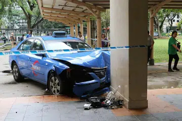 TERBABAS: Beginilah keadaan teksi Comfort yang terbabas memasuki kolong sebuah blok lembaga Perumahan dan Pembangunan (HDB) di Toa Payoh apabila berlaku pelanggaran dengan teksi TransCab. - Foto WANBAO