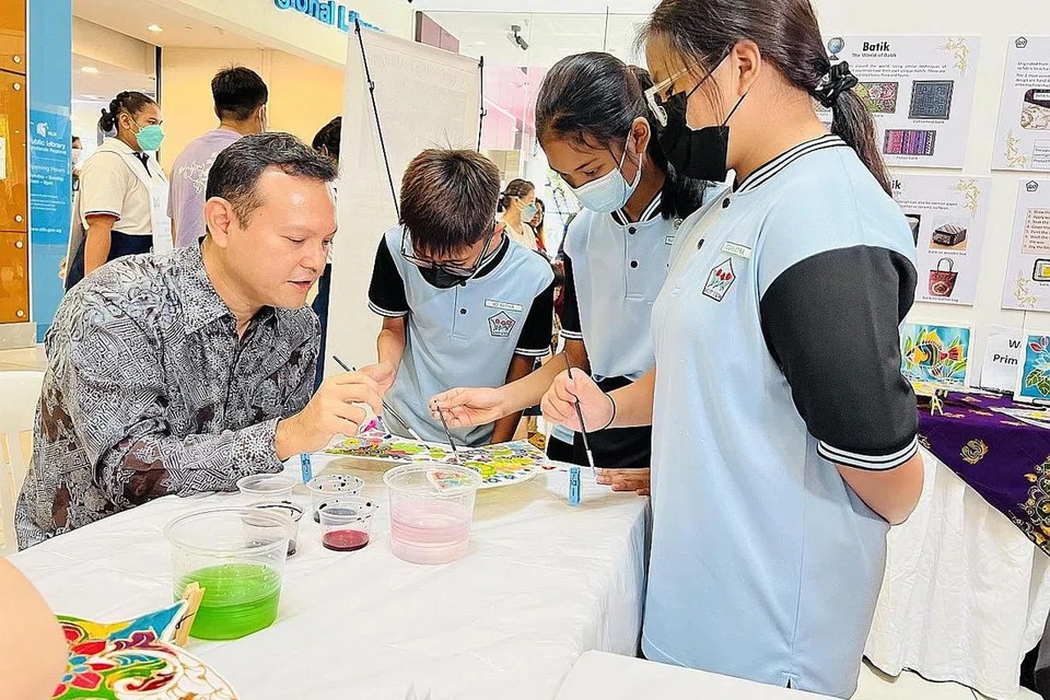 RAI KEKAYAAN BAHASA, BUDAYA DAN WARISAN MELAYU: Encik Zaqy menyertai aktiviti mewarnakan permainan tradisional Melayu bersama beberapa pelajar Sekolah Rendah West View di Pesta Bahasa dan Seni di Marsiling. - Foto BH oleh HAKIM YUSOF