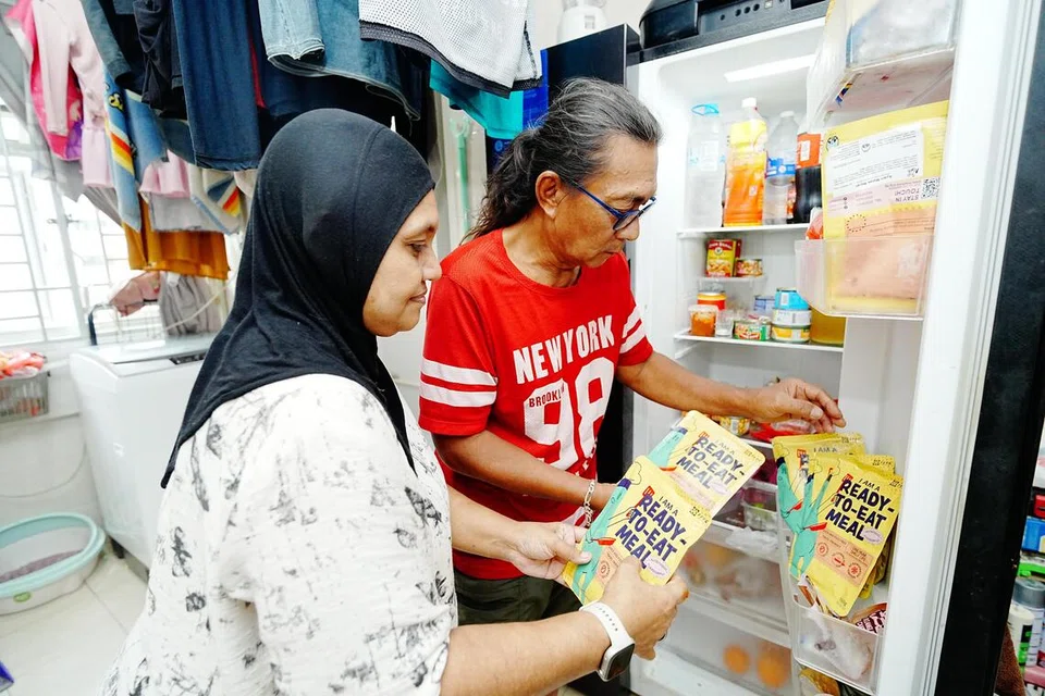Encik Johari (kanan) dan Cik Fariedah menerima sekitar 15 pek hidangan RTE setiap bulan, termasuk kari ayam dan ayam masak merah yang menjadi antara kegemaran keluarga.