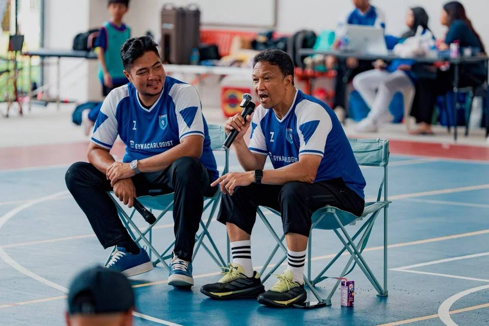 Peserta Kem Bola Sepak Singa Legends bukan sahaja dapat menimbu ilmu di atas padang, malah kanak-kanak serta ibu bapa mereka juga dapat mendengar perkongsian dan nasihat daripada legenda bola sepak Singapura, Fandi Ahmad (kanan). Di sebelahnya ialah pengerusi Singa Legends, Farehan Hussein.