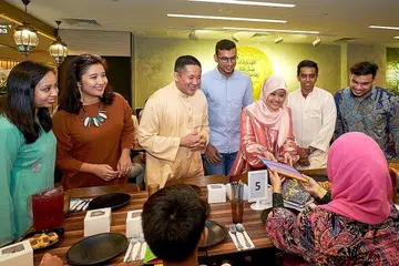 HULUR SUMBANGAN: Cik Rahayu (tiga dari kanan) dan Encik Amrin (tiga dari kiri) bersama beberapa pegawai guaman Islam setempat termasuk (dari kiri) Cik Fathiah Najwa, Cik Nadia Samdin, Encik Masoor Amir (tengah), Encik Hairul Hakkim (dua dari kanan) dan Encik Rano Matiin Nurhanes, menyampaikan sumbangan keperluan balik ke sekolah kepada salah seorang penerima bantuan. - Foto BH oleh ROSLEE ABDUL RAZAK