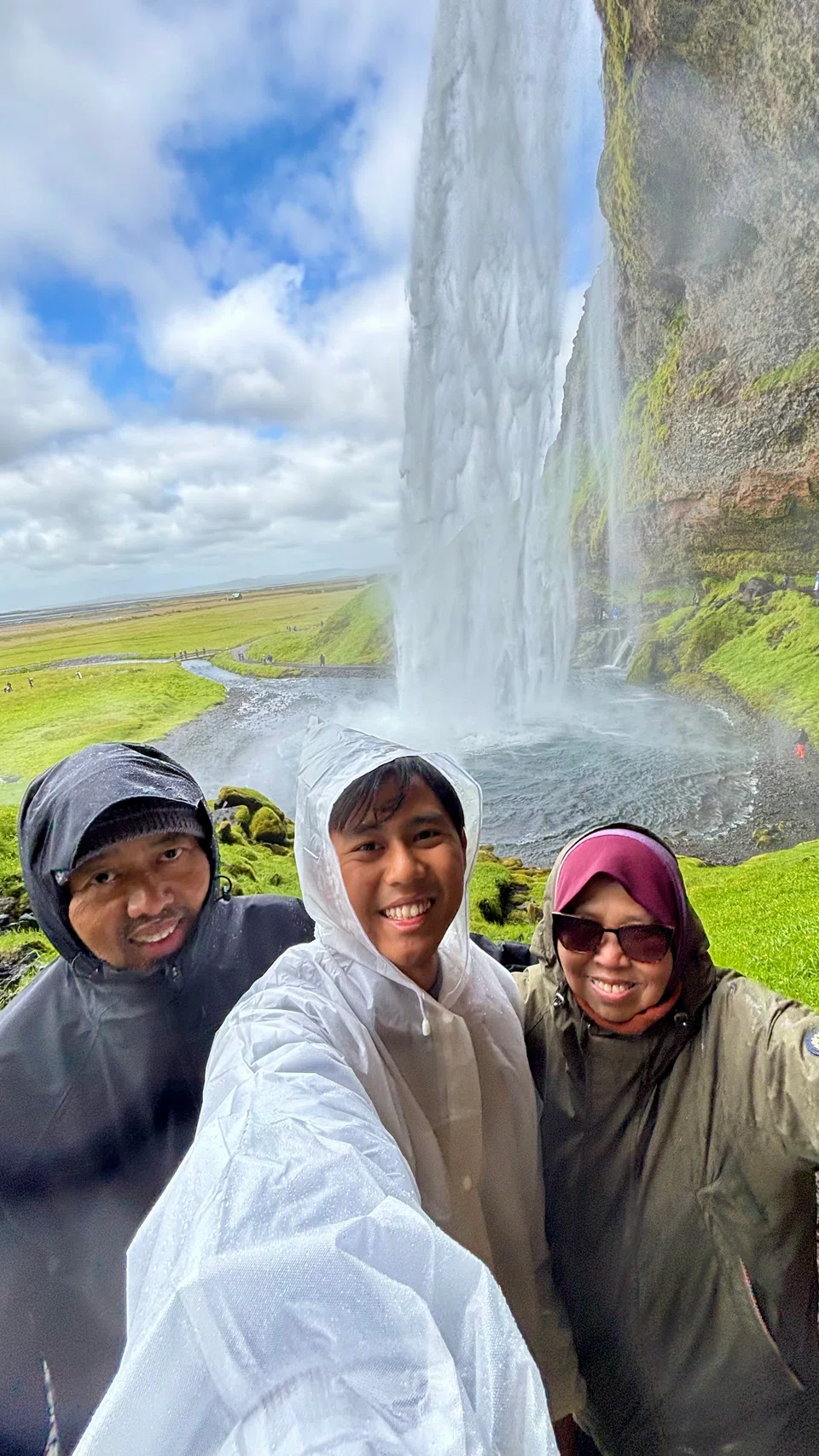Cik Rehana M Salleh, suaminya, Encik Jaafar Junali (kiri) dan anak bongsunya, Encik Muhd Haatim Jaafar berjalan di belakang air terjun Seljalandsfoss.