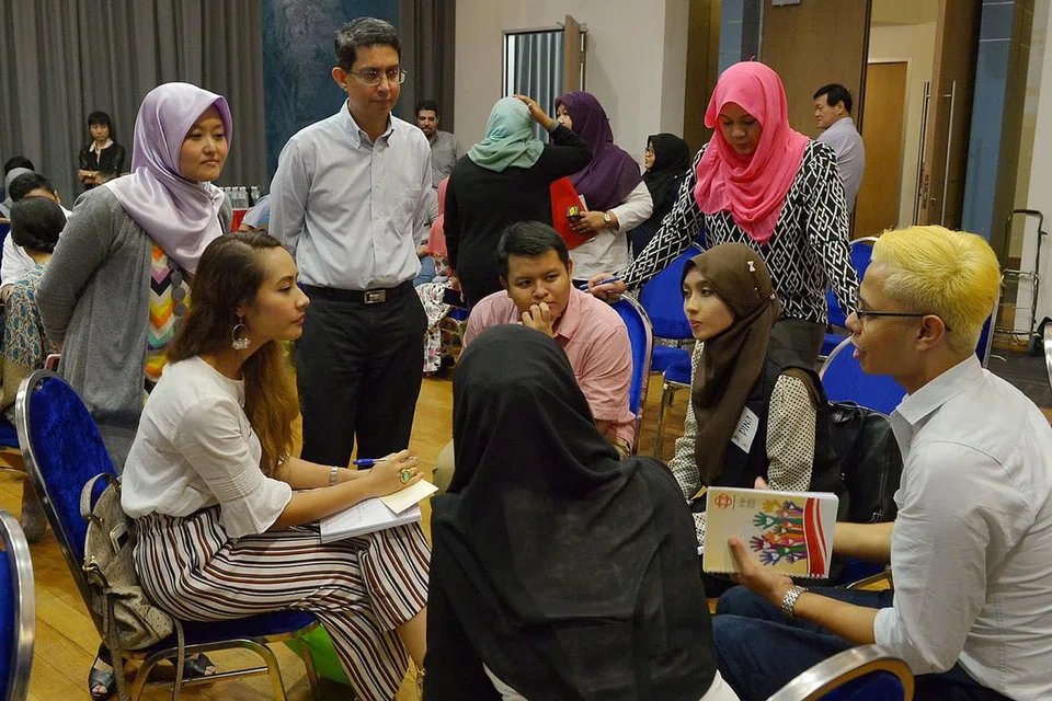 RANCAK BERBINCANG: Dr Faishal (berdiri) dan Anggota Parlimen Jurong, Cik Rahayu Mahzam (kiri), mendengar perbincangan beberapa wakil pertubuhan Melayu/Islam dan Jawatankuasa Eksekutif Kegiatan Melayu (MAEC) mengenai aspirasi belia bagi masa depan Singapura. - Foto TUKIMAN WARJI