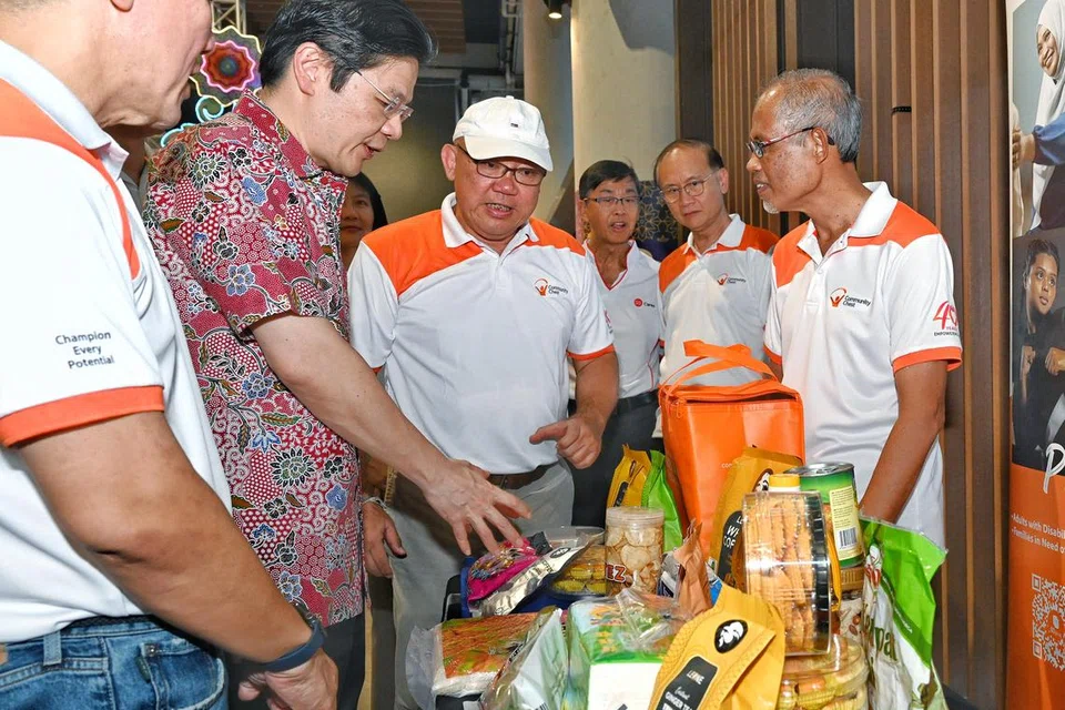 Timbalan Perdana Menteri, Encik Lawrence Wong (dua dari kiri), bersama Pengerusi Dana Masyarakat, Encik Chew Sutat (kiri); Pengasas Heartwarmers, Encik Foo Say Thye (tiga dari kiri) dan Menteri Pembangunan Sosial dan Keluarga yang juga Menteri Kedua Kesihatan merangkap Menteri Bertanggungjawab bagi Ehwal Masyarakat Islam, Encik Masagos Zulkifli Masagos Mohamad (kanan), di rerurai yang menampilkan isi kandungan pakej perayaan. 