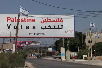 Papan iklan pilihan raya Parlimen Palestin di tepi jalan berhampiran Jenin, Tebing Barat, pada 25 September 2026, dengan bendera Israel kelihatan berdekatan. Pilihan raya dijadualkan pada 28 November, tetapi perpecahan politik dan sekatan Israel menimbulkan keraguan terhadap pelaksanaannya.