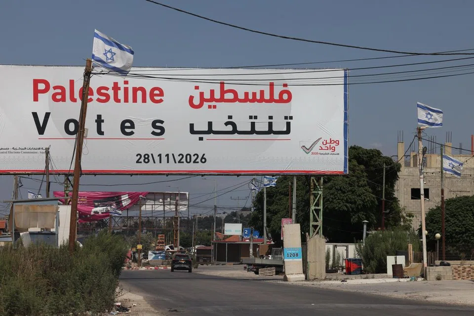 Papan iklan pilihan raya Parlimen Palestin di tepi jalan berhampiran Jenin, Tebing Barat, pada 25 September 2026, dengan bendera Israel kelihatan berdekatan. Pilihan raya dijadualkan pada 28 November, tetapi perpecahan politik dan sekatan Israel menimbulkan keraguan terhadap pelaksanaannya.