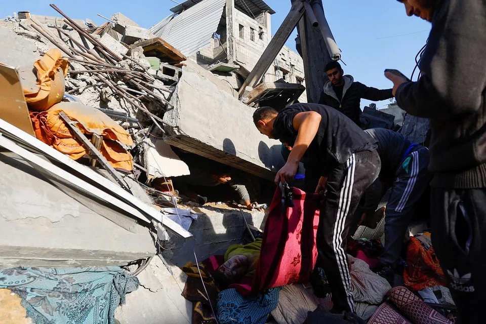  ISRAEL MENGGEMPUR: Para penduduk mencari dan cuba menyelamatkan mangsa yang terbunuh dan tercedera dalam serangan udara tentera Israel di Khan Younis, selatan Gaza, pada 10 Disember.