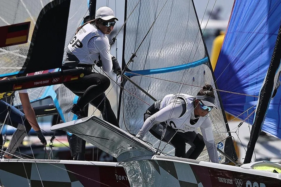PUAS HATI: Lim (kiri) dan Low ketika beraksi di perlumbaan pingat 49er FX di Pelabuhan Kapal Layar Enoshima pagi semalam. - Foto REUTERS