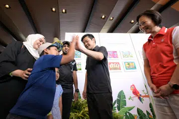 INISIATIF BARU: Timbalan Perdana Menteri Encik Lawrence Wong (dua dari kanan) bermesra dengan seorang kanak-kanak yang menyertai Hari Keluarga PCF di Bird Paradise. Bersamanya (kanan) Menteri Negara (Pendidikan merangkap Tenaga Manusia), Cik Gan Siow Huang.