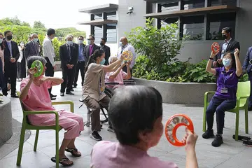 TINJAU KEMUDAHAN: Encik Masagos Zulkifli memerhatikan warga emas melibatkan diri dalam kegiatan muzik di Pusat Jagaan Rumah St. John's-St. Margaret's (SJSM) semalam. - Foto BH oleh KEVIN LIM