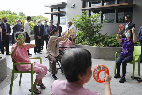 TINJAU KEMUDAHAN: Encik Masagos Zulkifli memerhatikan warga emas melibatkan diri dalam kegiatan muzik di Pusat Jagaan Rumah St. John's-St. Margaret's (SJSM) semalam. - Foto BH oleh KEVIN LIM