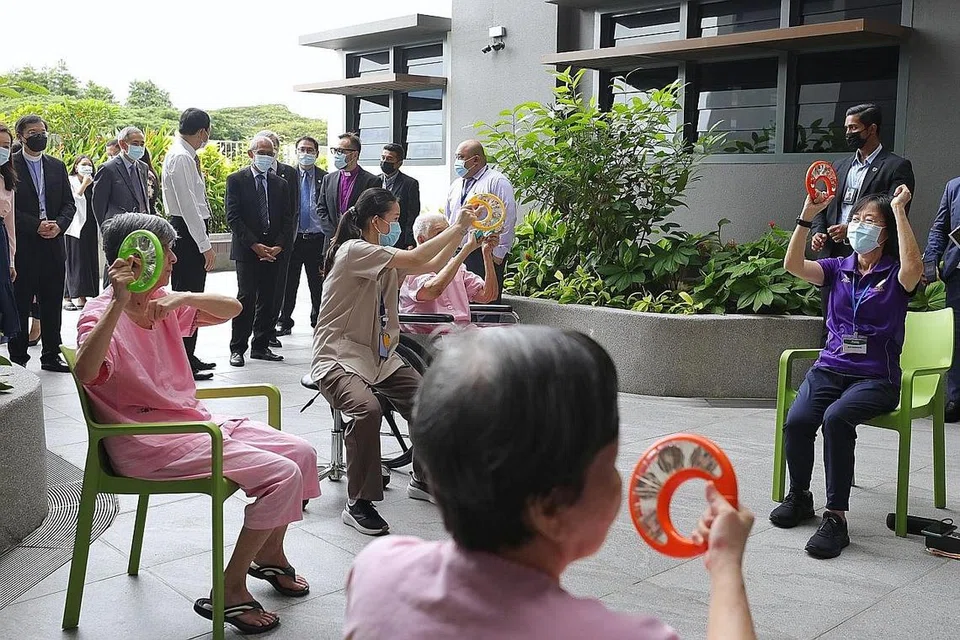 TINJAU KEMUDAHAN: Encik Masagos Zulkifli memerhatikan warga emas melibatkan diri dalam kegiatan muzik di Pusat Jagaan Rumah St. John's-St. Margaret's (SJSM) semalam. - Foto BH oleh KEVIN LIM
