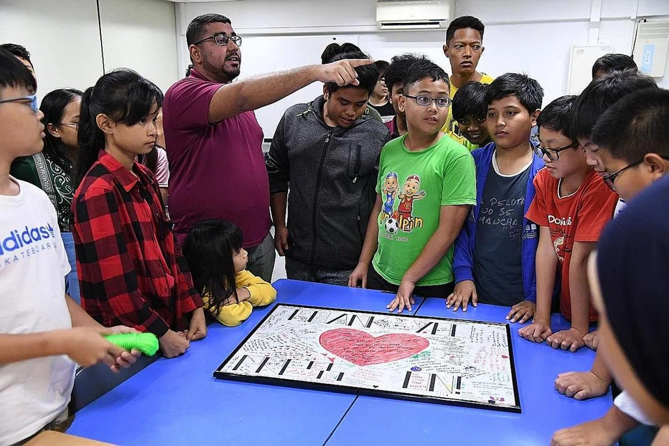 PERKUKUH SEMANGAT BERPASUKAN: Encik Muhammad Akram (dua dari kiri) bersama remaja yang menghasilkan papan kata-kata perangsang. - Foto BM oleh DESMOND FOO