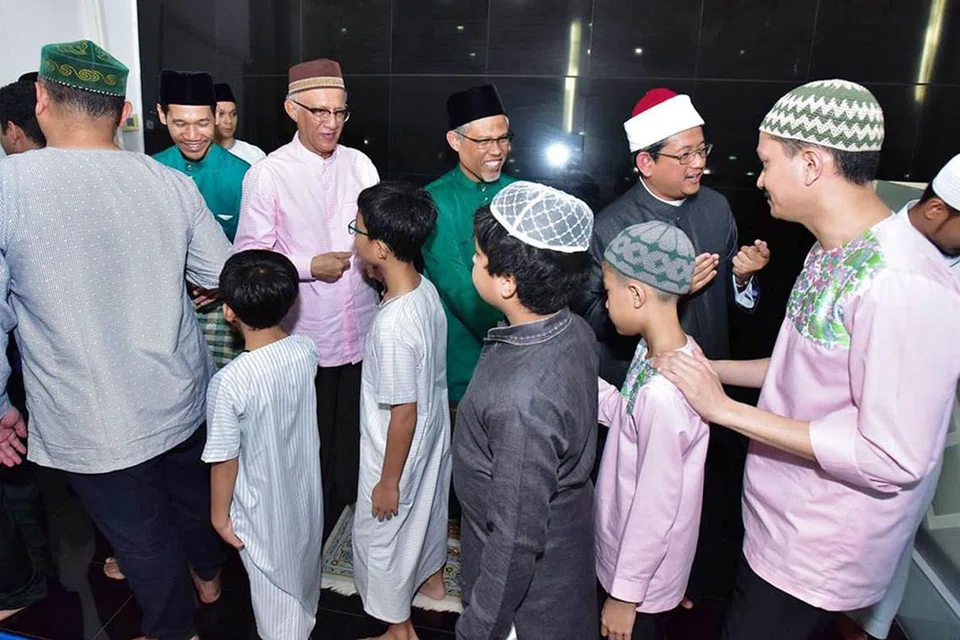 SALAM AIDILADHA: Encik Masagos Zulkifli; Mufti Dr Fatris Bakaram; dan suami Presiden Halimah Yacob, Encik Mohamed Abdullah Alhabshee meluangkan masa bersalaman dengan jemaah selepas solat Aidiladha di Masjid Al-Mawaddah semalam. - Foto MUIS