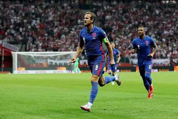 TUGAS BELUM SELESAI: Kapten England Harry Kane (kiri) meraikan golnya dalam perlawanan kelayakan Piala Dunia menentang Poland di Warsaw kelmarin. - Foto REUTERS