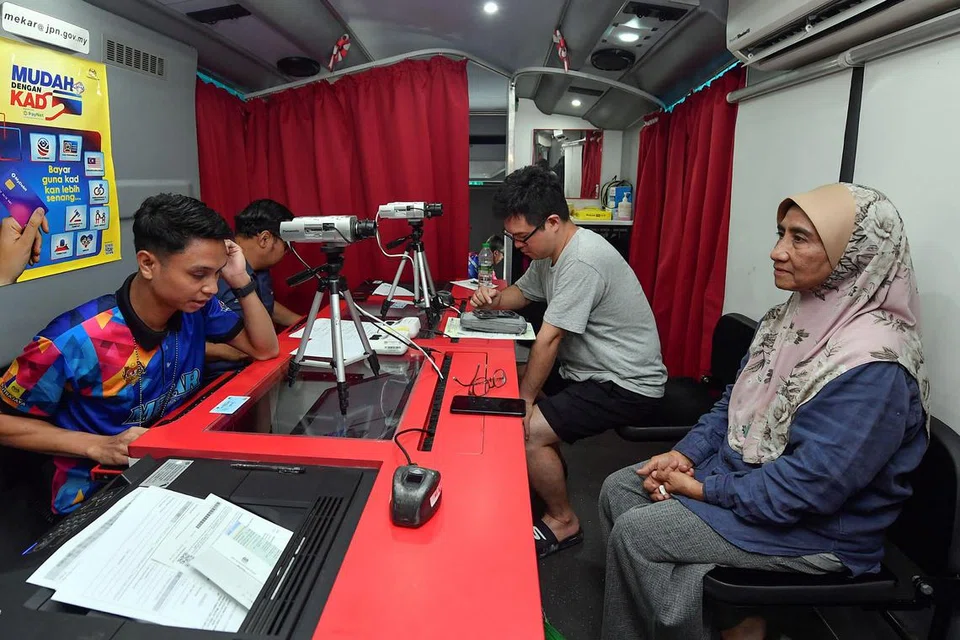 Mangsa kejadian kebakaran memperbaharui kad pengenalan diri yang rosak secara percuma kaunter Jabatan Penerangan Malaysia yang dibuka di Pusat Pemindahan Sementara di Masjid Putra Heights.