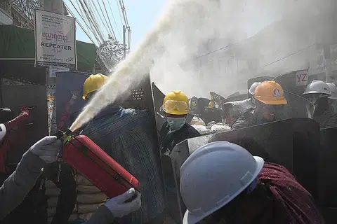 CUBA SELAMATKAN DIRI: Penunjuk perasaan cuba menjejas daya penglihatan pasukan berkuasa dengan menyembur pemadam api yang mengeluarkan kepulan buih bagi menyelamatkan diri, apabila pasukan berkuasa bertindak terhadap pembantah. - Foto AFP