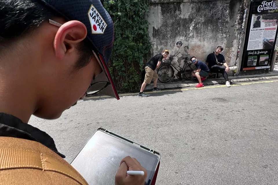 Aniq sedang membuat ilustrasi digital untuk dicetak menjadi sepanduk sempena Hari Keluarga (Family Day) 2019