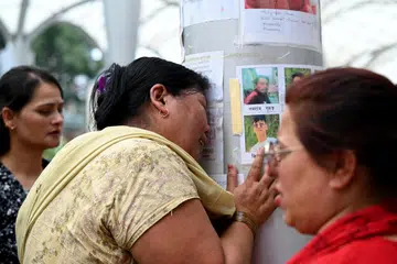 Seorang wanita yang anak lelakinya masih hilang melihat gambar mangsa yang belum ditemukan, yang ditampal pada tiang di luar Hospital Pengajar Universiti Tribhuvan di Kathmandu, Nepal, pada 1 September 2026. Hampir 4,500 orang masih hilang, manakala harapan untuk menemukan lebih ramai mangsa yang terselamat semakin tipis, seminggu selepas banjir besar dan tanah runtuh melanda kawasan Himalaya.
