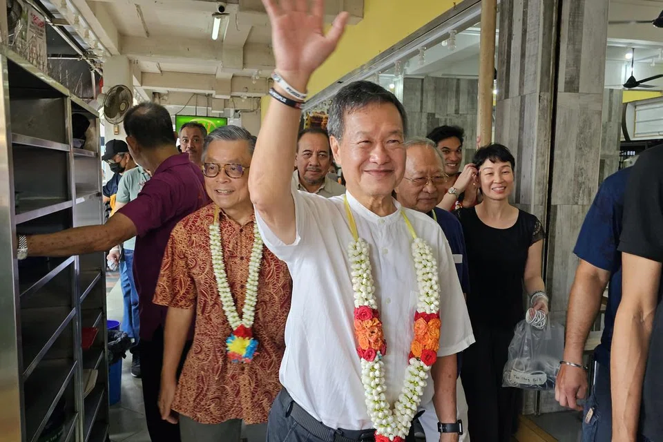 TIGA TAN BERSAMA: Calon Pilihan Raya Presiden, Encik Tan Kin Lian, melawat Pusat Makanan People’s Park pada Ahad, diiringi oleh Encik Tan Jee Say (kiri) dan Dr Tan Cheng Bock (tiga dari kiri).