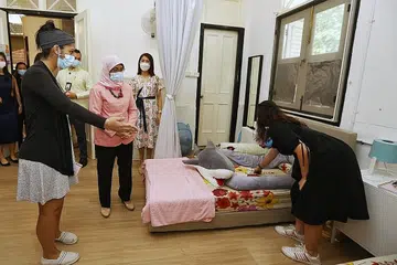 PERJALANAN SEORANG IBU: Puan Halimah (dua dari kiri) mengunjungi Safe Place oleh Perkhidmatan Keluarga Lakeside semalam untuk mendekati benefisiari di bawah inisiatif itu. - Foto ZAOBAO