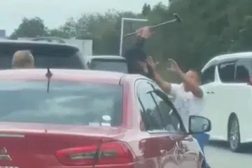 Tangkap layar video tular menunjukkan lelaki dipercayai warga asing (tengah) yang memandu Mitsubishi Lancer gunakan tongkat kayu ketika bergaduh dalam kesesakan di Lebuhraya Utara-Selatan, dekat Pagoh, Johor, pada 10 Februari.