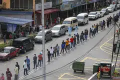 DAFTAR PENDUDUK: Penduduk di sekitar Pasar Raja Bot di Kampong Bharu beratur bagi menjalani pemeriksaan Covid-19 di Kuala Lumpur, Malaysia. Negara itu membuka semula ekonomi buat pertama kali sejak 4 Mei lalu selepas Perintah Kawalan Pergerakan dikuatkuasakan pada 18 Mac lalu. Di bawah peraturan baharu, semua pekerja asing di tapak binaan, kilang, bangunan komersial dan restoran perlu menjalani pemeriksaan Covid-19. 