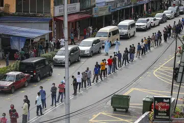 DAFTAR PENDUDUK: Penduduk di sekitar Pasar Raja Bot di Kampong Bharu beratur bagi menjalani pemeriksaan Covid-19 di Kuala Lumpur, Malaysia. Negara itu membuka semula ekonomi buat pertama kali sejak 4 Mei lalu selepas Perintah Kawalan Pergerakan dikuatkuasakan pada 18 Mac lalu. Di bawah peraturan baharu, semua pekerja asing di tapak binaan, kilang, bangunan komersial dan restoran perlu menjalani pemeriksaan Covid-19. 