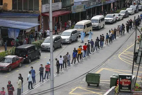 DAFTAR PENDUDUK: Penduduk di sekitar Pasar Raja Bot di Kampong Bharu beratur bagi menjalani pemeriksaan Covid-19 di Kuala Lumpur, Malaysia. Negara itu membuka semula ekonomi buat pertama kali sejak 4 Mei lalu selepas Perintah Kawalan Pergerakan dikuatkuasakan pada 18 Mac lalu. Di bawah peraturan baharu, semua pekerja asing di tapak binaan, kilang, bangunan komersial dan restoran perlu menjalani pemeriksaan Covid-19. 