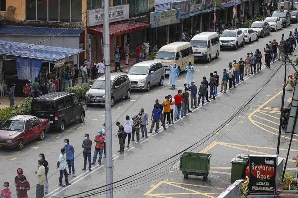 DAFTAR PENDUDUK: Penduduk di sekitar Pasar Raja Bot di Kampong Bharu beratur bagi menjalani pemeriksaan Covid-19 di Kuala Lumpur, Malaysia. Negara itu membuka semula ekonomi buat pertama kali sejak 4 Mei lalu selepas Perintah Kawalan Pergerakan dikuatkuasakan pada 18 Mac lalu. Di bawah peraturan baharu, semua pekerja asing di tapak binaan, kilang, bangunan komersial dan restoran perlu menjalani pemeriksaan Covid-19. 