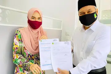 SOKONGAN BERSAMA: Pengerusi Eksekutif Masjid Ar-Raudhah, Ustaz Mohamed Ali Atan menyerahkan borang keahlian Skim Pintar kepada pegawai masjid, Cik Siti Nur Amalina Naimat. - Foto-foto MASJID AR-RAUDHAH