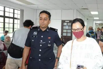 Seorang pempengaruh warga Singapura, Amyra Laila Ho, 45 tahun (kanan), didenda RM1,000 oleh Mahkamah Majistret Johor Bahru atas tuduhan membuat laporan palsu.