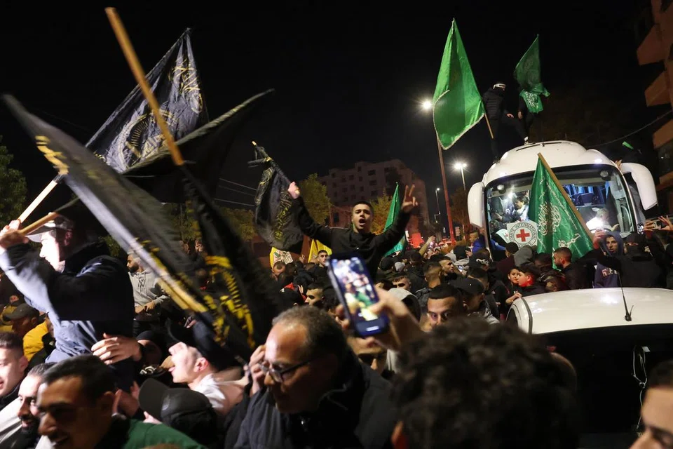 GEMBIRA SAMBUT YANG TERSAYANG: Rakyat Palestin bersorak gembira apabila bas yang membawa tahanan Palestin yang dibebaskan dari penjara tentera Israel, Ofer, tiba di Ramallah, Tebing Barat, pada 1 Disember. 