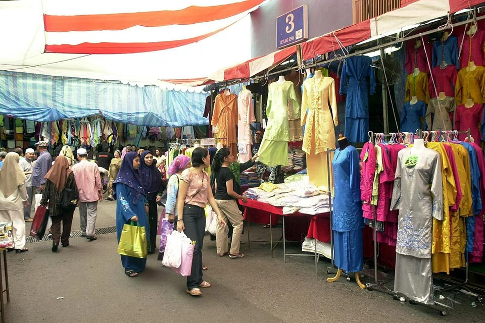 Orang ramai bersiar-siar di bazar Geylang Serai, melihat pakaian dan barangan lain yang dijual, dalam gambar yang diambil pada Ogos 2007 ini. 