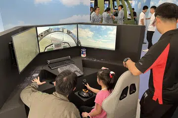 SIMULASI TERBANG PESAWAT: Rumah Terbuka RSAF tahun ini  menawarkan pelbagai reruai permainan, termasuk sebuah stesen simulasi, dimana orang ramai boleh mengemudi sebuah pesawat maya. 