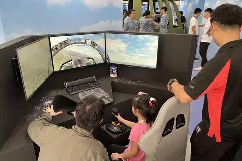 SIMULASI TERBANG PESAWAT: Rumah Terbuka RSAF tahun ini  menawarkan pelbagai reruai permainan, termasuk sebuah stesen simulasi, dimana orang ramai boleh mengemudi sebuah pesawat maya. 
