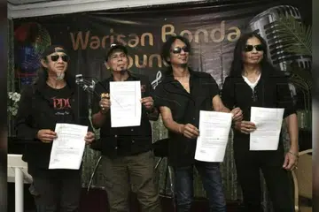 Kumpulan XPDC Kita Peng Yu menunjukkan dokumen berkaitan isu penggunaan nama XPDC di Hotel Grand Barakah, Ampang, pada 9 Julai. 