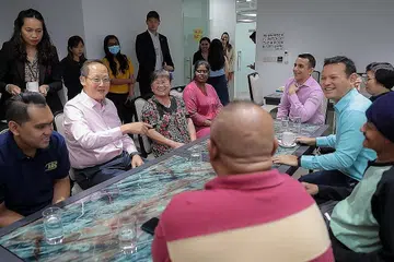 TEMU PEKERJA: Dr Tan See Leng (dua dari kiri) dan Encik Zaqy Mohamad (baju biru muda) bertemu pekerja bergaji rendah semasa lawatan ke syarikat Radha Exports di Pioneer Road semalam. - Foto BH oleh GAVIN FOO