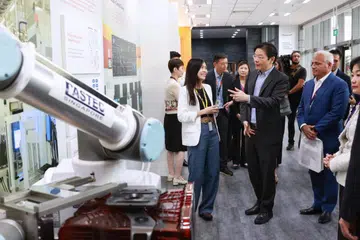 LAWAT KILANG: Encik Lawrence Wong (depan, dua dari kiri) melawat GlobalFoundries semasa majlis perasmian berikutan peluasan kilang tersebut.