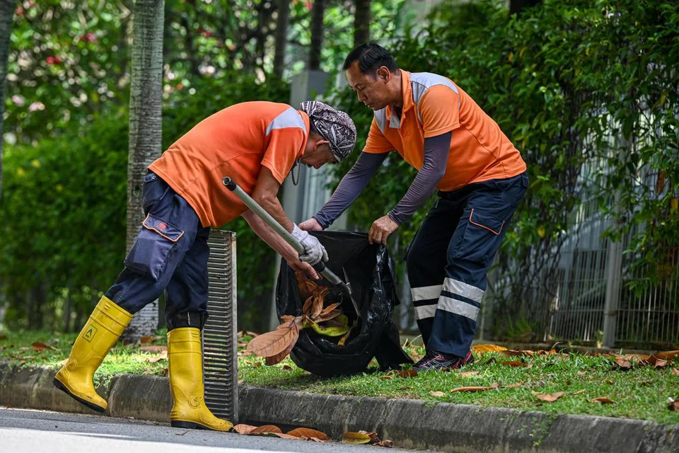 Pekerja pembersihan sibuk mengeluarkan daun yang gugur dari longkang di tepi jalan. Langkah itu penting bagi mengelakkan longkang daripada tersumbat dan meningkatkan risiko banjir.