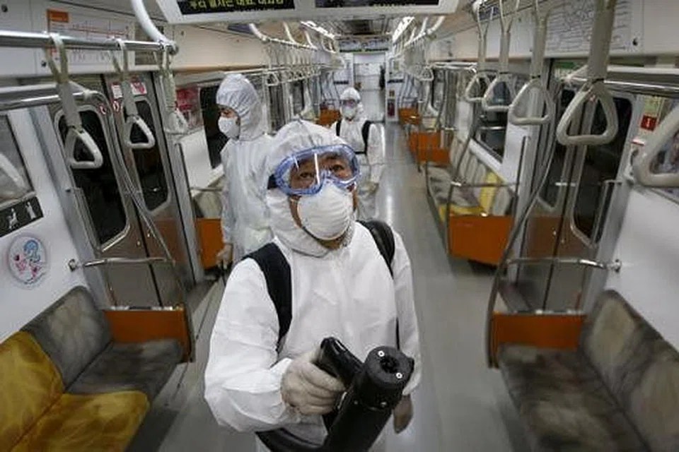 BASMI KUMAN: Pekerja siap berpakaian perlindungan menyembur pembasmi kuman dalam tren Metro Seoul di Goyang, Korea Selatan, semalam. - Foto REUTERS